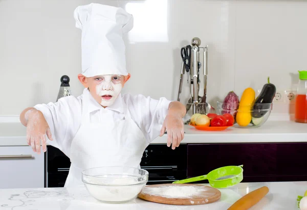 Schattige kleine jongen chef-kok in de keuken — Stockfoto