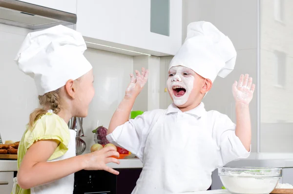 Glad liten pojke och flicka bakning i köket — Stockfoto