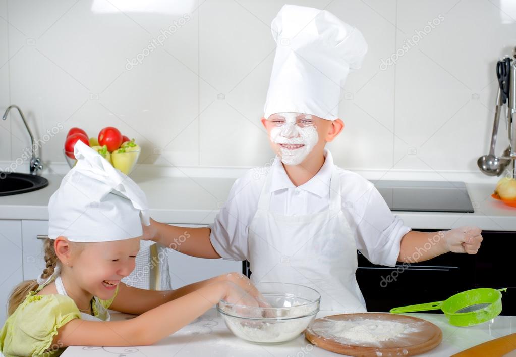 Two cute young children learning to bake