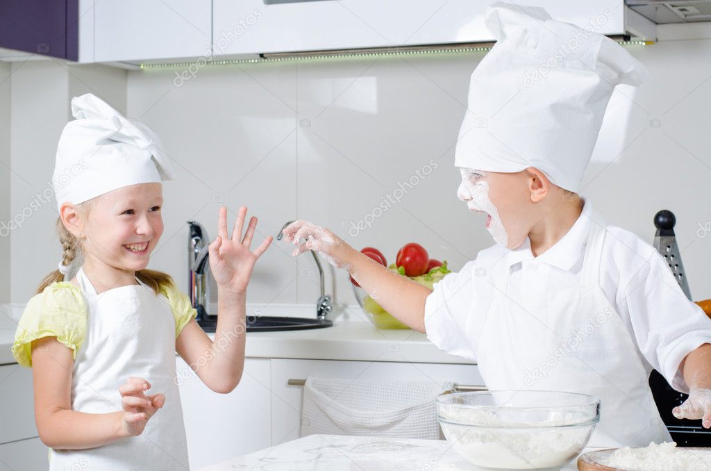 Happy little boy and girl baking in the kitchen