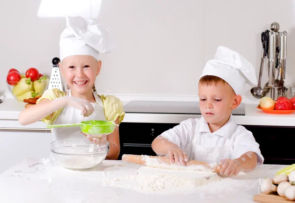 Deux jeunes enfants heureux apprenant à cuisiner — Photo