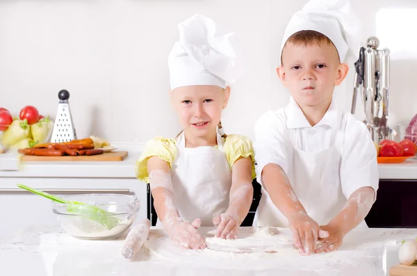 Gelukkig weinig jongen en meisje koken in de keuken — Stockfoto