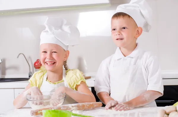 Glad liten pojke och flicka matlagning i köket — Stockfoto