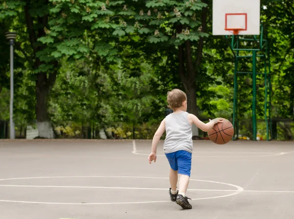 Ung pojke spelar basket — Stockfoto