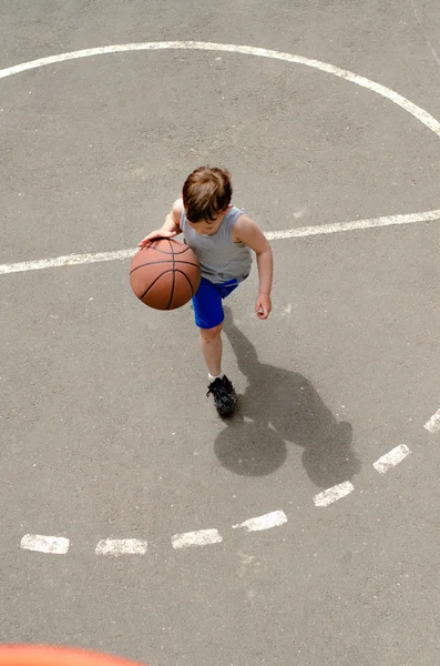 Jovem menino jogar basquete — Fotografia de Stock