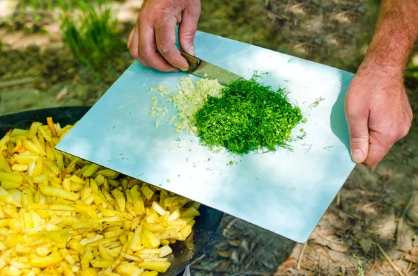 Man chopping herbs and spices to add to a BBQ — Stock Photo, Image