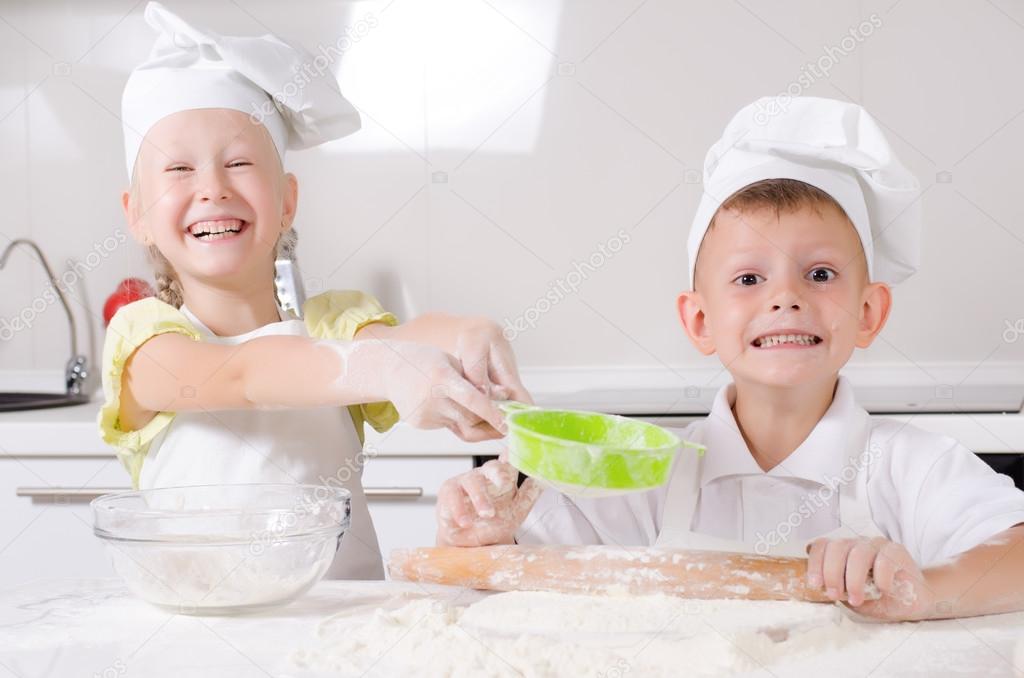 Cheeky happy little boy and girl in the kitchen
