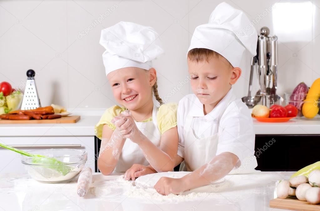 Happy little boy and girl cooking in the kitchen