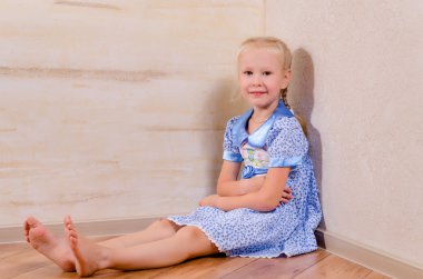 jonge meisje zit in de hoek