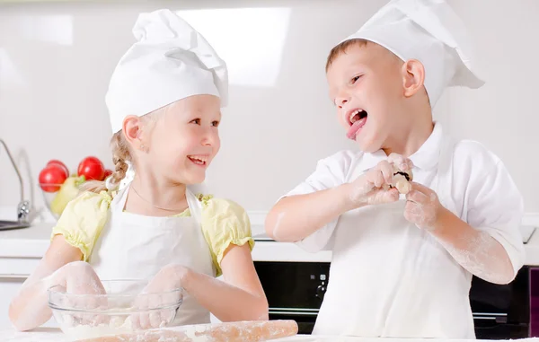 Menino e menina feliz cozinhar na cozinha — Fotografia de Stock