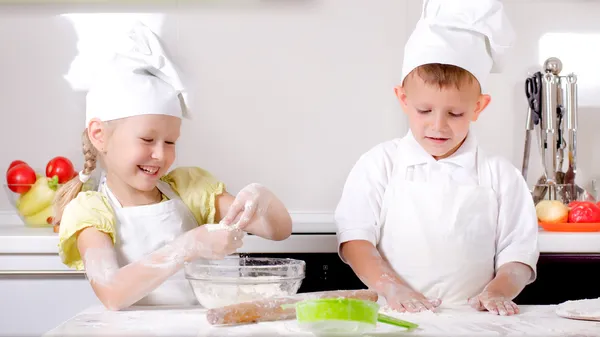 Menino e menina feliz cozinhar na cozinha — Fotografia de Stock