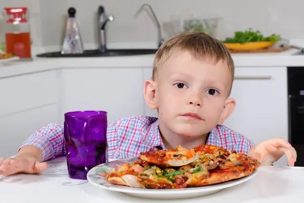 Petit garçon mangeant une grande assiette de pizza — Photo