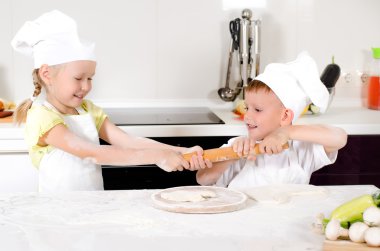 Two young children fighting over a rolling pin clipart