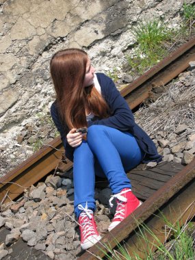 raylar üzerinde oturan genç kız