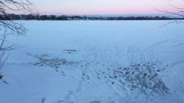 凍結した川の上を移動する雪の中で残されたトラックの上に低い空の景色 — ストック動画