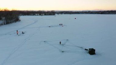 Laval-Ouest 'teki donmuş bir nehrin insansız hava aracı görüntüsü ve buz balıkçıları ve kulübeler.