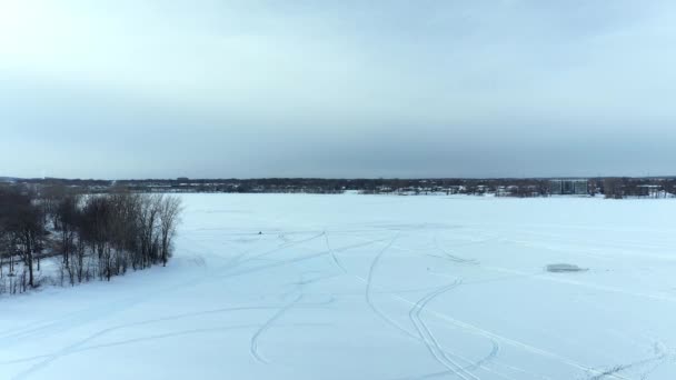 空中ドローンの景色が見えます彼は凍った川を下り ラバル Outest 24FpsのBerge Des Goelandsで雪の中で子供たちとラウンドトラックによって作られた雪の砦を示しています — ストック動画