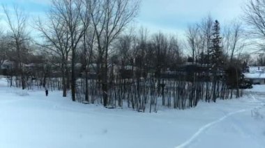 Hava aracı Laval-Ouest 'teki Berge-des-Goeland' ın çevresini donuk nehir kenarında bir bayanla birlikte gösteriyor.