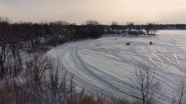 Hava aracının sağa dönüşü, Laval-Ouest-24fps 'deki Berges-des-Quatre-vent' te gün batımında donmuş nehir ve kış manzarası üzerindeki kamp karavanlarını gösteriyor.