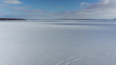 Bir İHA ile Oka 'daki donmuş İki Dağlı Gölü' nün üzerinden yüksekten uçuyor ve beyaz kar ve mavi gökyüzüyle uçurtmacıya doğru ilerliyor.