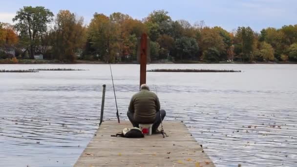 Rybář Sedící Konci Mola Viděn Zezadu Svou Výstrojí Podzimním Dni — Stock video