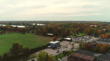 Drone video rotating from left to right above the colorful trees of Fall, during a sunny day with some clouds