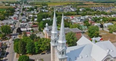 St. Jacques de Montcalm kilisesinin yüksek açılı drone çekimi çanların etrafında dönüyor ve etrafındaki köyü ortaya çıkarıyor.