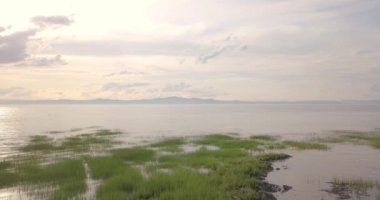 Aerial view of a pink colored sunset over the calm water of the St-Lawrence River in La Pocatiere, Quebec