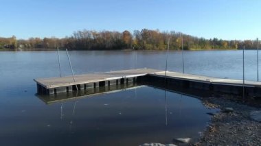 İnsansız hava aracı, hareketli bir platformun üzerinden düşerken sessiz nehre doğru alçaktan uçuyor.