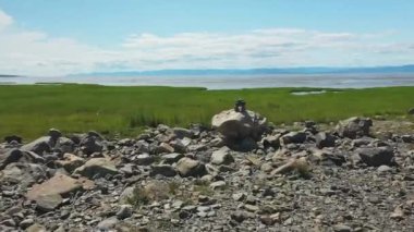 Mini bir Inukshuk 'un üzerine kurulmuş ve La Pocatiere, Quebec' in manzarasını gösteren havadan insansız hava aracı videosu.