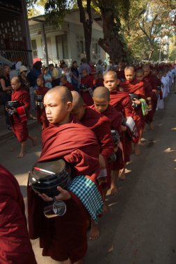 sadaka ve mandalay yakınındaki amarapura teklifleri toplamaya Budist acemiler yürümek