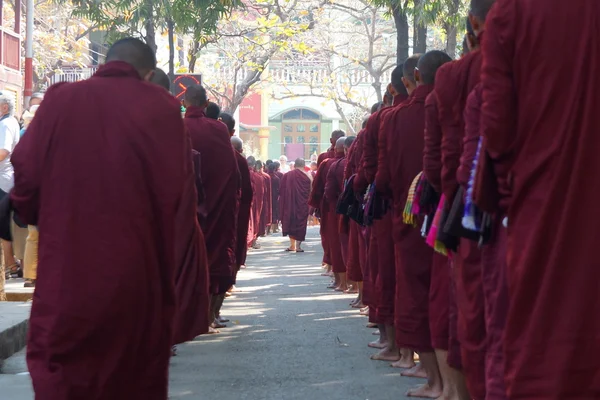 Буддийские новички ходят собирать милостыню и подношения в Амарапуре возле Мандалая — стоковое фото