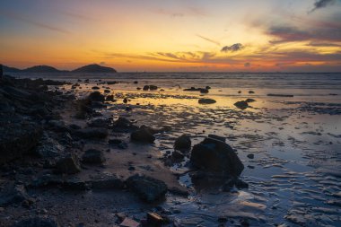 Scene of beach during low tide before sunrise at Saphanhin, Phuket city, Thailand.