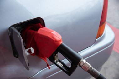 Fuel nozzle in the car tank. Refueling gasoline at petrol station.