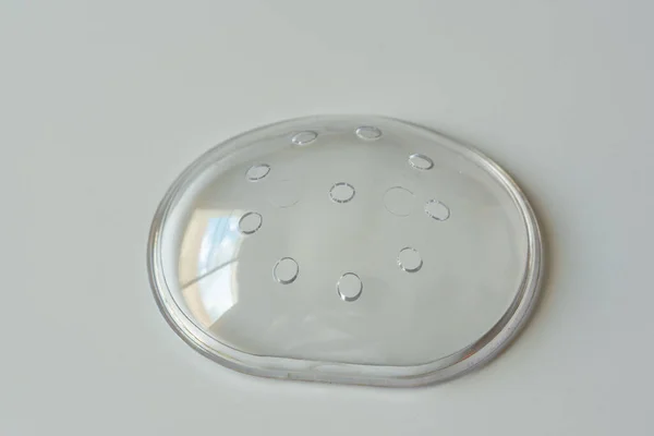 A clear plastic protective eye shield on white background