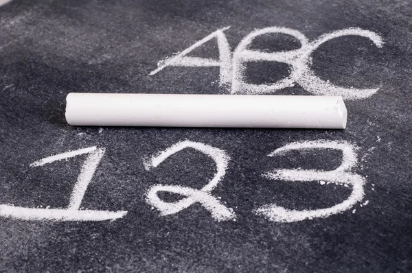 Abc and 123 on Chalkboard with Piece of Chalk. — Stock Photo, Image