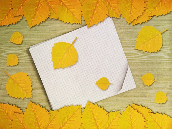 Yellow leaves over wooden background — Stock Photo, Image