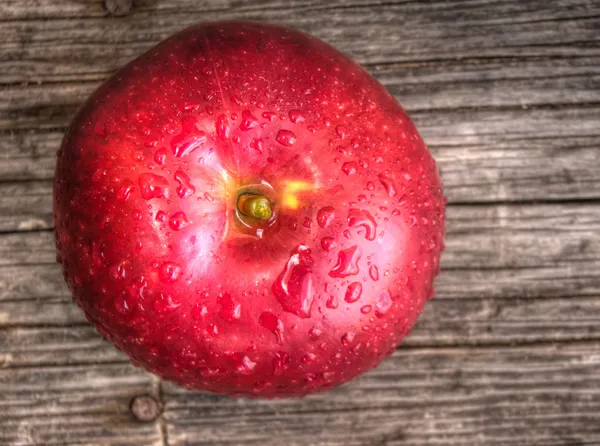 Jabłko z kropli wody na stole — Darmowe zdjęcie stockowe