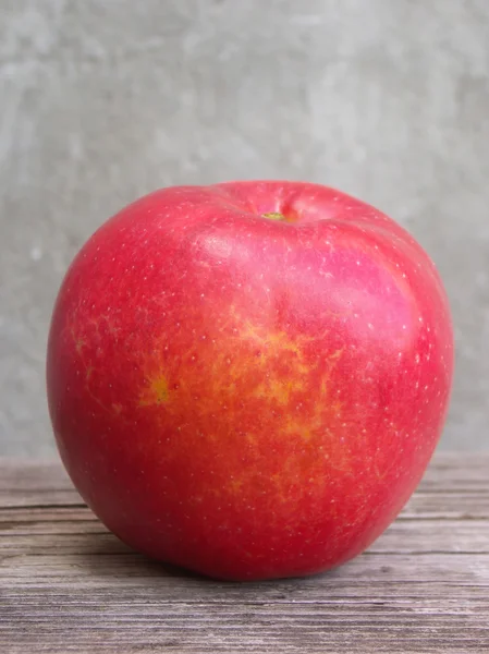 Rött äpple på träbord — Stockfoto