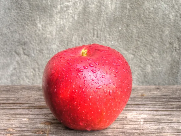 Jabłko z kropli wody na stole — Zdjęcie stockowe