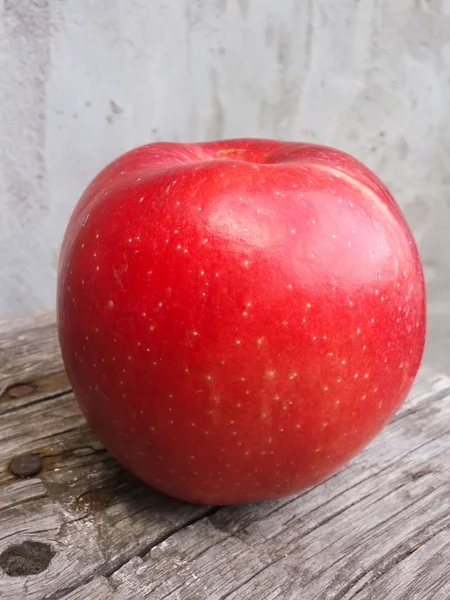 Roter Apfel über Betonmauer — Stockfoto