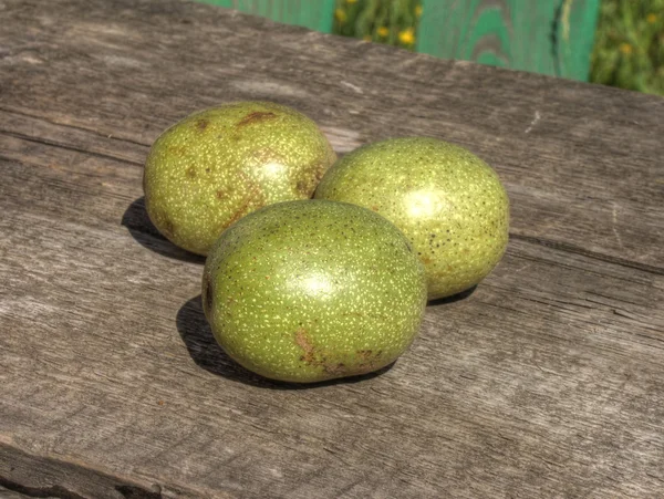 Green walnuts on table — Stock Photo, Image