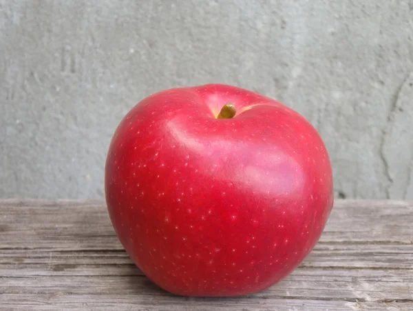 Czerwone jabłko na drewnianym stole — Zdjęcie stockowe