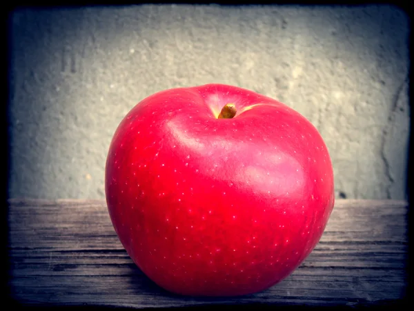 Červené jablko na dřevěném stole — Stock fotografie
