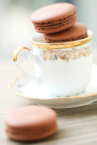 Chocolate macarons in tea cup — Stock Photo, Image