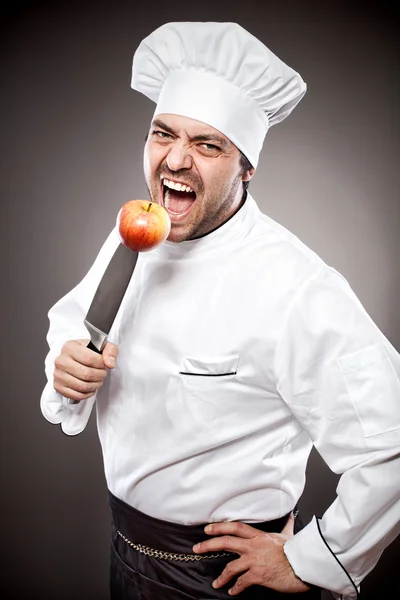 Chef with apple on knife — Stock Photo, Image
