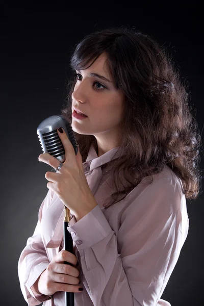 Attractive young woman with a retro microphone — Stock Photo, Image