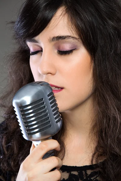 Attraente giovane donna con un microfono retrò — Foto Stock