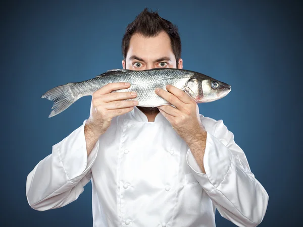 Young handsome chef with sea bass — Stock Photo, Image