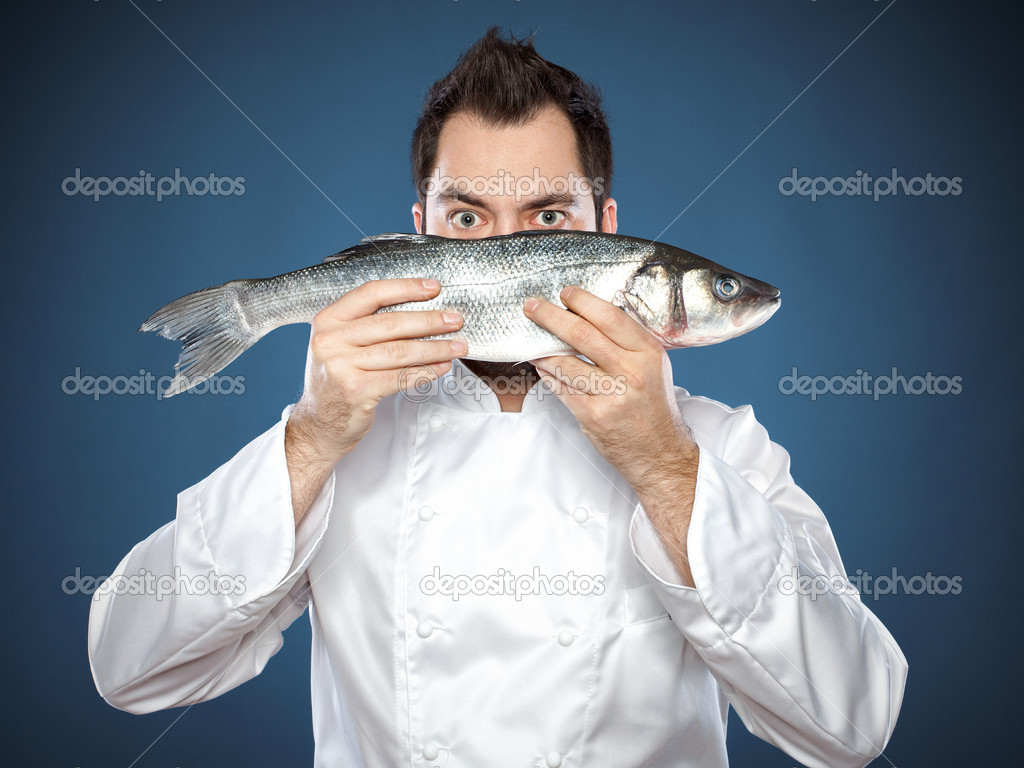 Young handsome chef with sea bass